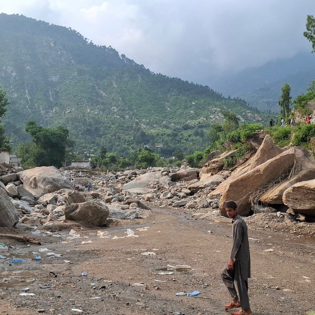 Ein Junge läuft durch das inzwischen trockene Bett einer Schlammlawine.