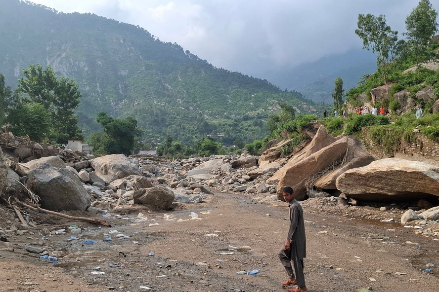 Ein Junge läuft durch das inzwischen trockene Bett einer Schlammlawine.